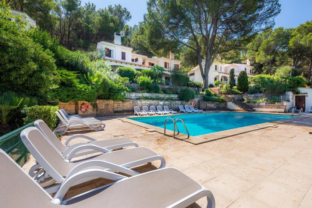 a swimming pool with lounge chairs next to a house at Can Botana 7 in Cala de Sant Vicenc