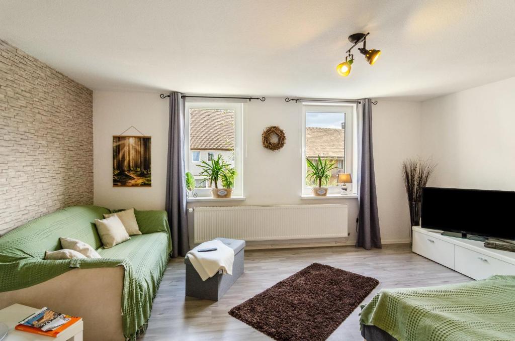 a living room with a couch and a tv at Ferienwohnung am Vogler in Holenberg