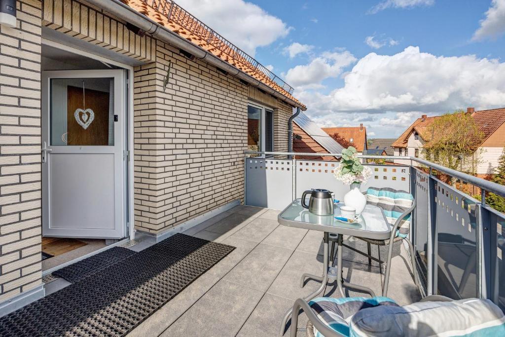 a small balcony with a table and a door at Weserberglandblumen in Bad Pyrmont