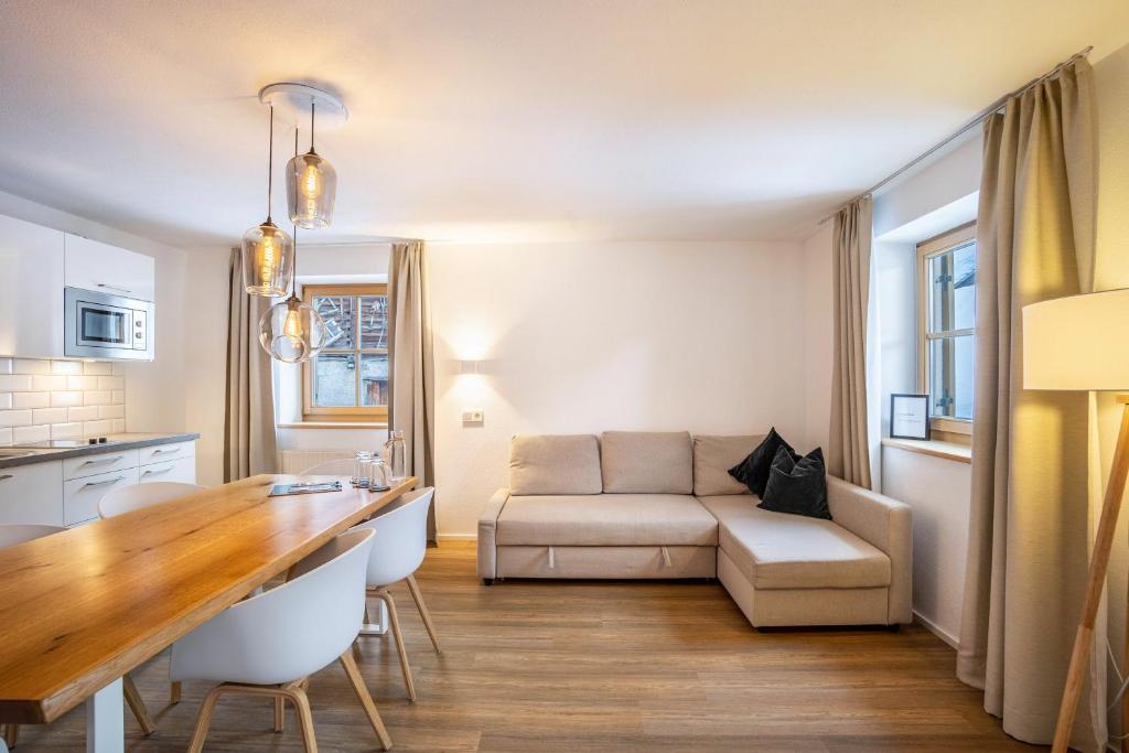 a kitchen and living room with a couch and a table at Mountain Residence Kasern Nr 1 in Predoi