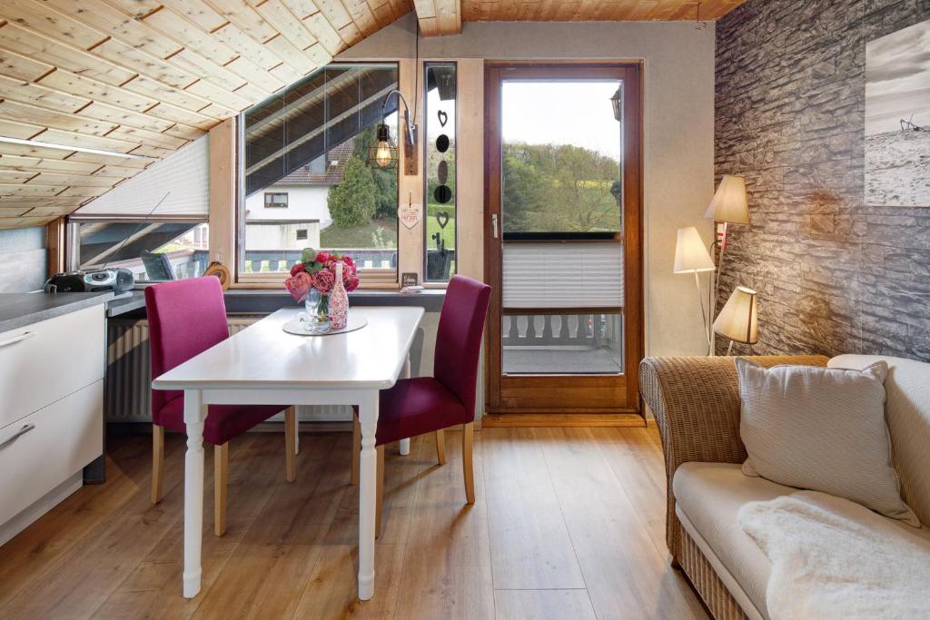 a kitchen and dining room with a white table and purple chairs at Landharmonie Knüll in Frielendorf