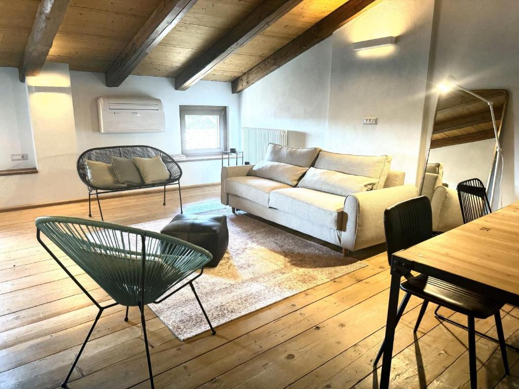 a living room with a couch and a table and chairs at Vicolo 10 in Asti