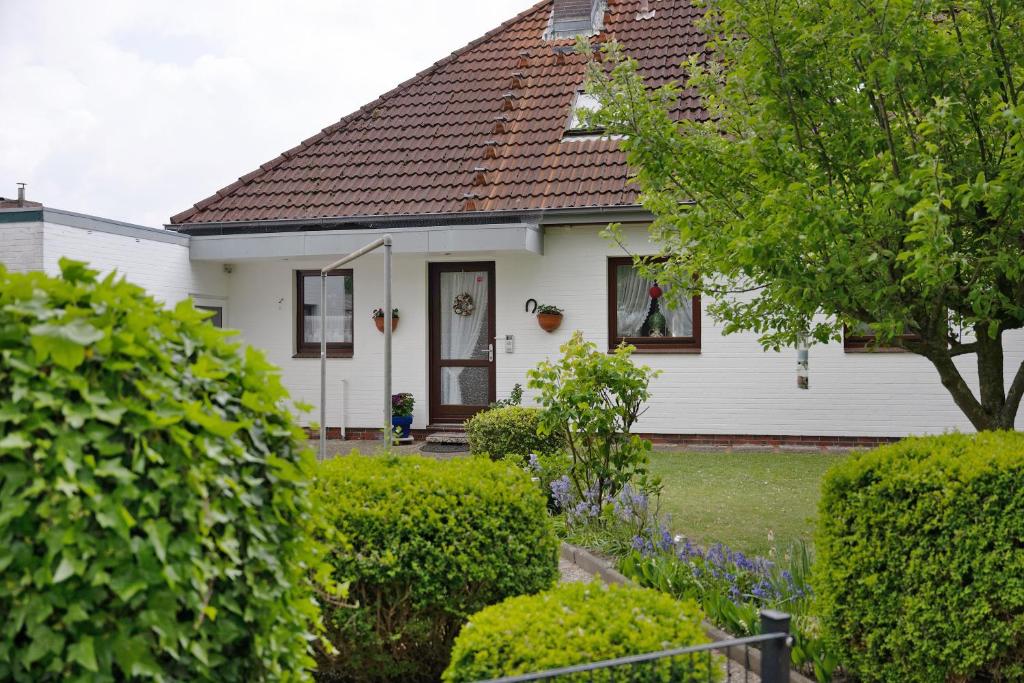 a white house with a brown roof at Haus Hachmann Wesselburen in Wesselburen