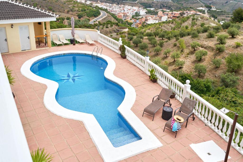 a swimming pool on a patio next to a house at Villa Soraida in Ítrabo