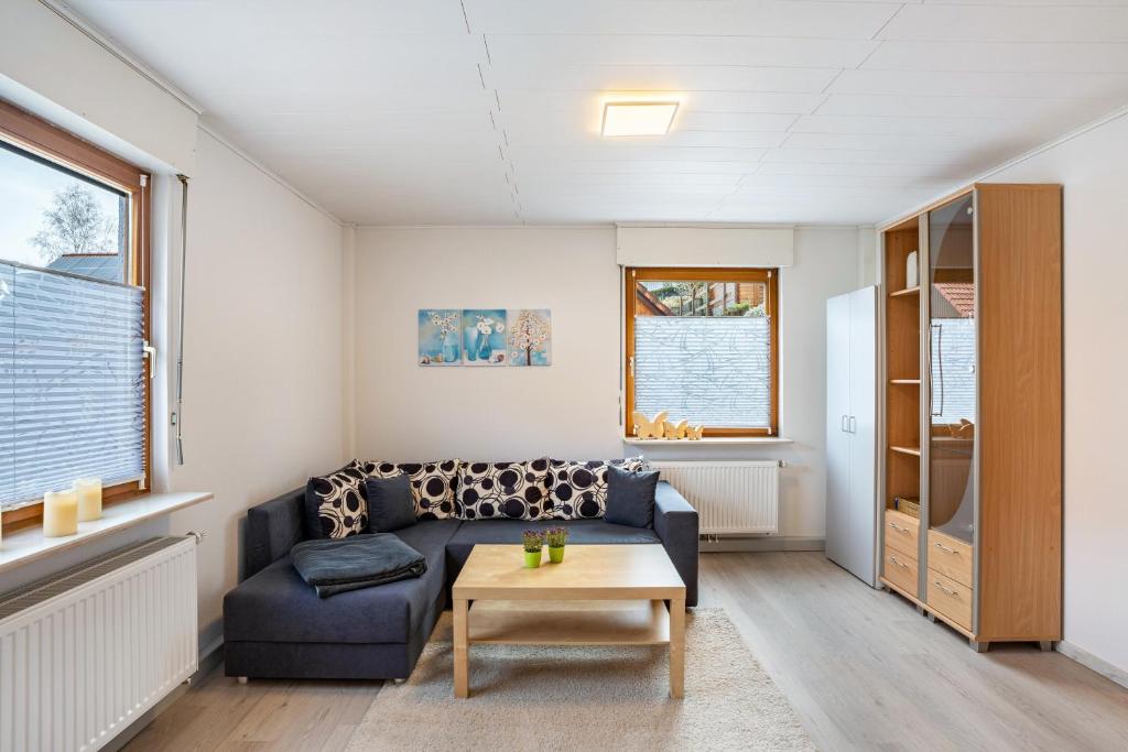 a living room with a blue couch and a table at Ferienwohnung Brigitte in Forbach