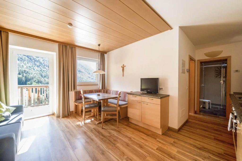 a kitchen and living room with a table and chairs at Sonnleiten der kleinen Bären 9 in Collepietra