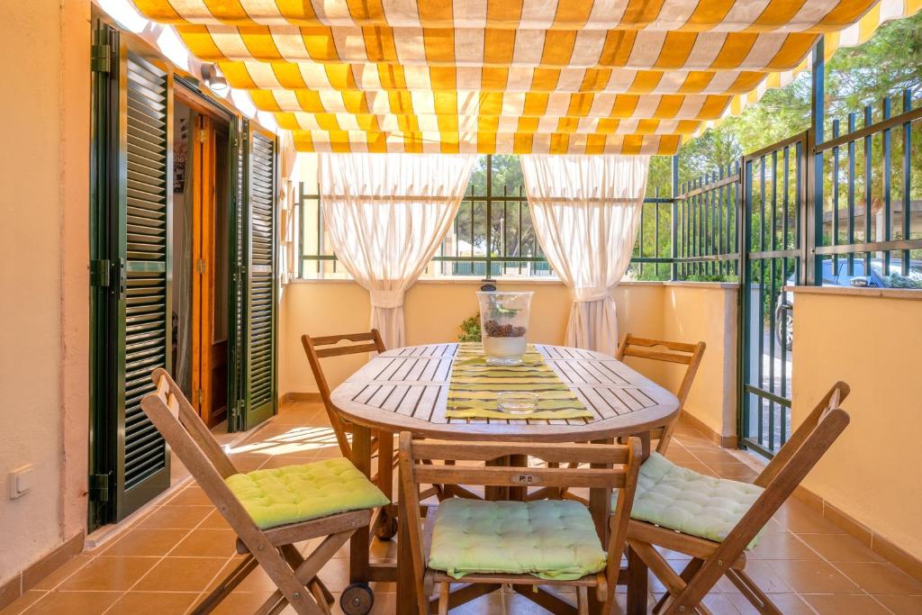 a dining room with a table and chairs on a balcony at Santa Eulalia in Can Picafort