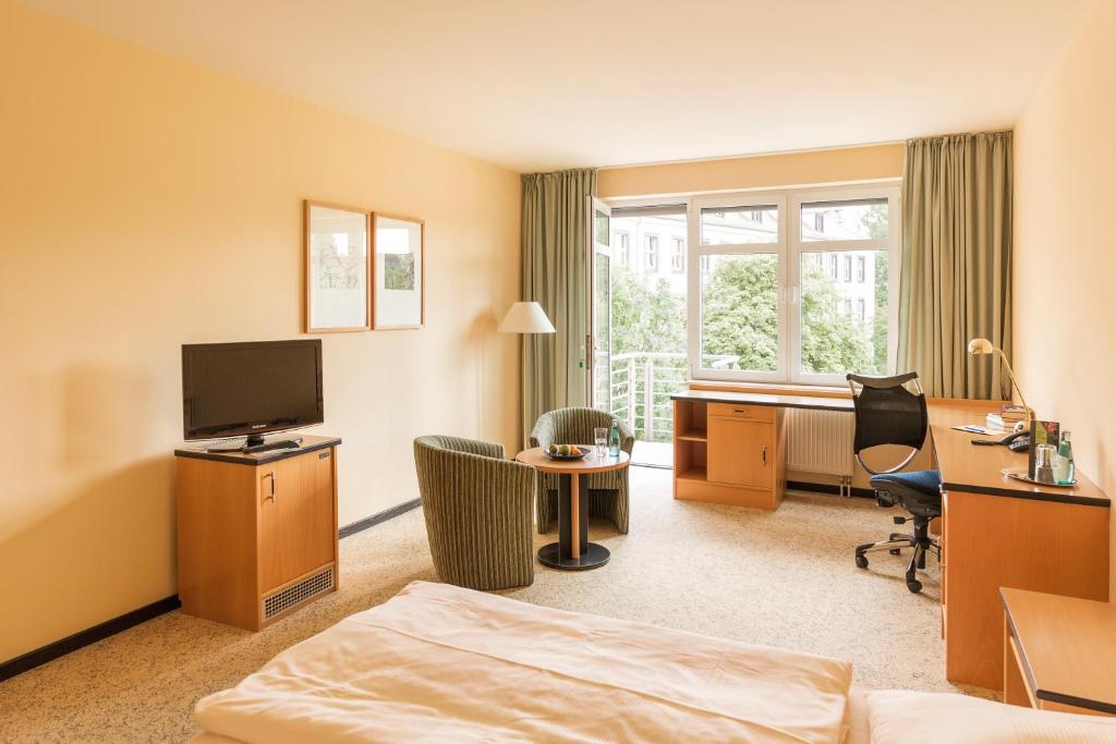 a hotel room with a bed and a desk at Hotel Am Weberplatz in Dresden