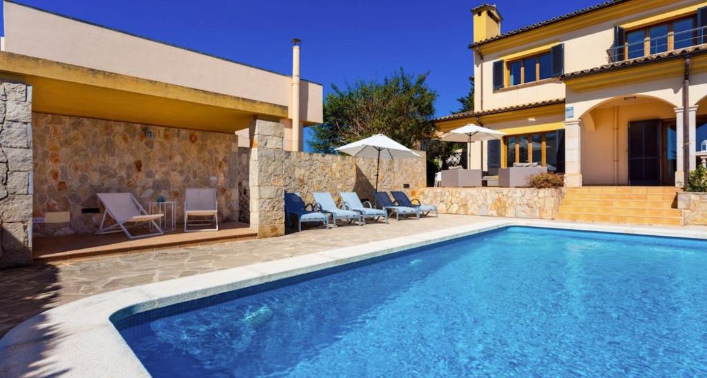 a villa with a swimming pool in front of a house at Ca Nostra in Son Servera