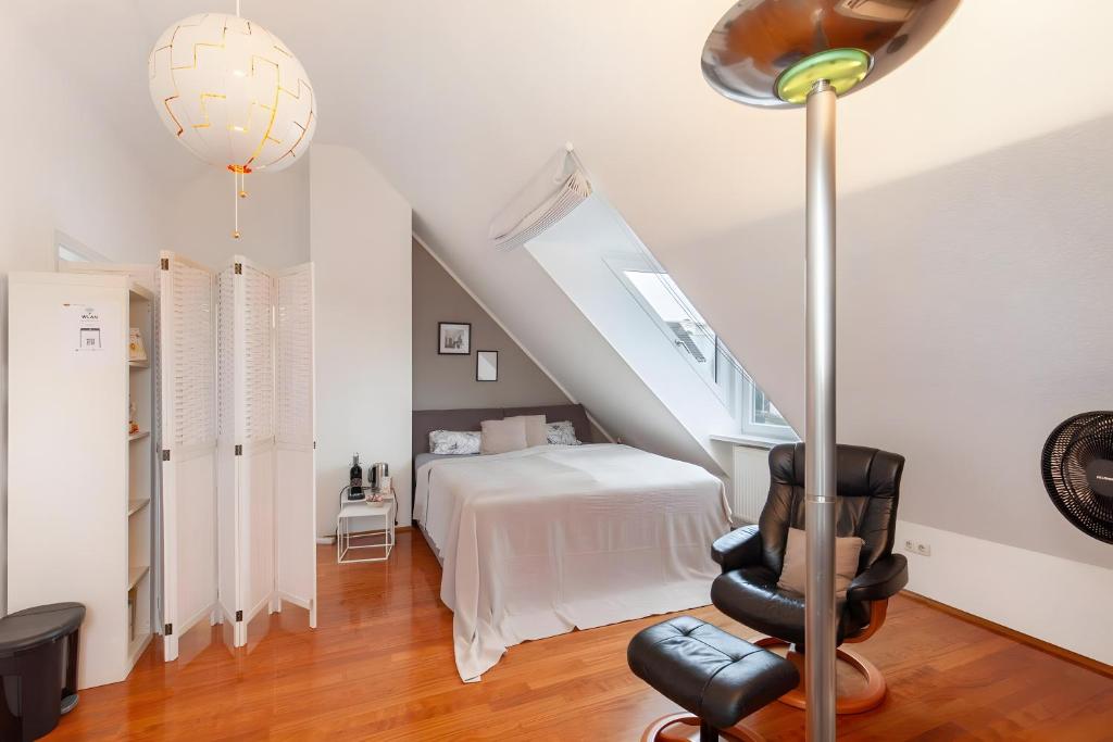 a room with a bed and a staircase with a chair at Skyline-Blick in Bad Soden am Taunus