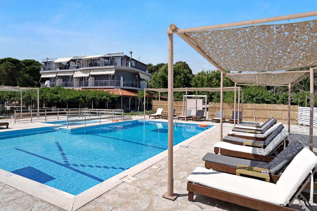 a swimming pool with lounge chairs next to a building at Iguana studio 7 in Preveza