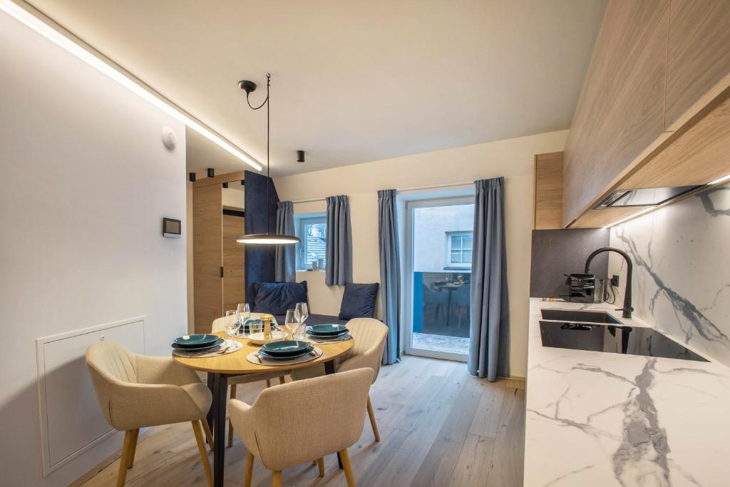 a dining room and kitchen with a table and chairs at Avia Living Maria in Brunico