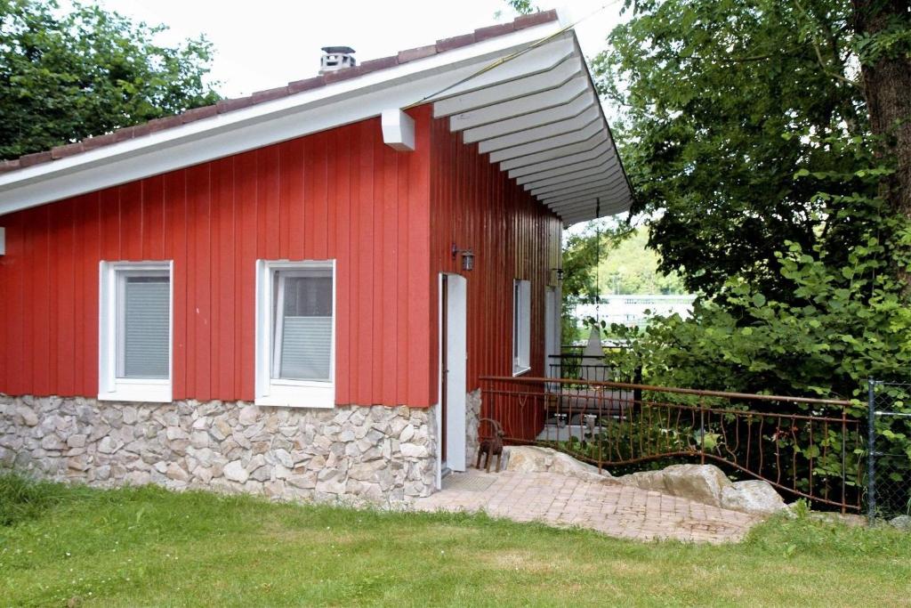 a red house with a stone facade and a dog standing outside at Gästehäusle Haag in Waldshut-Tiengen