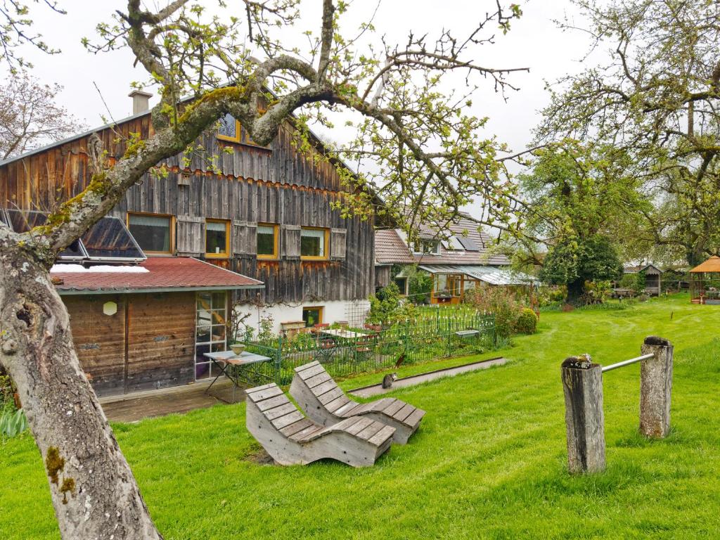 a chair sitting in the grass in front of a house at Ferienhaus am Ried in Ostrach