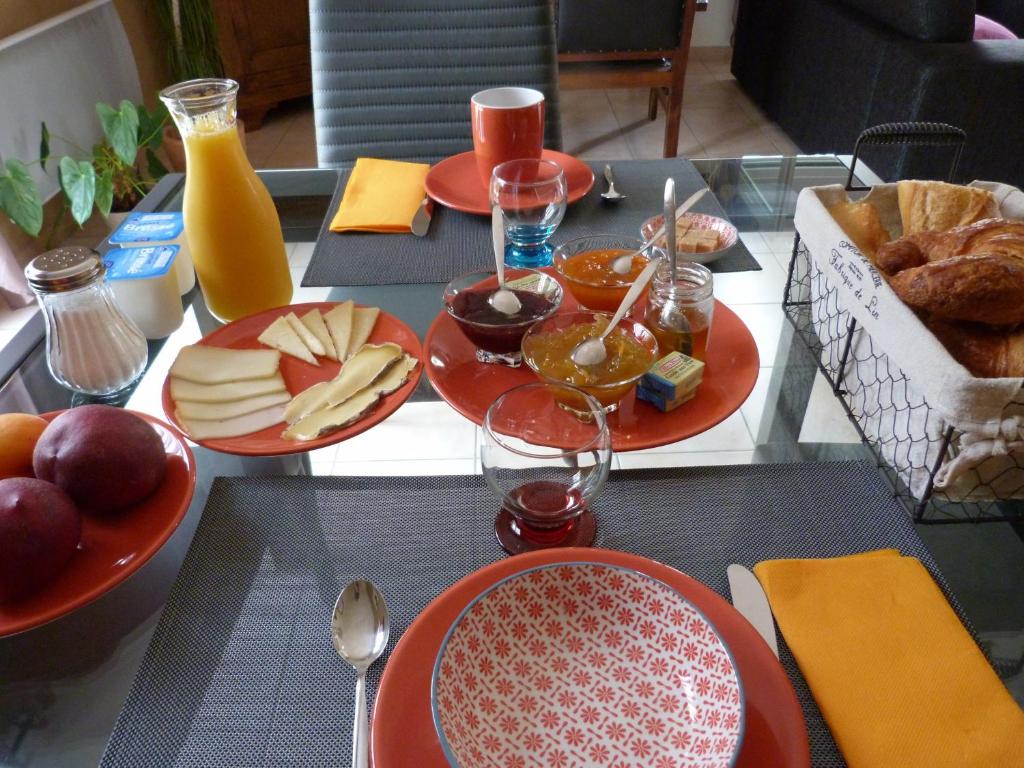 a table with red plates of food on it at La Chambre aux Oiseaux in Cayriech