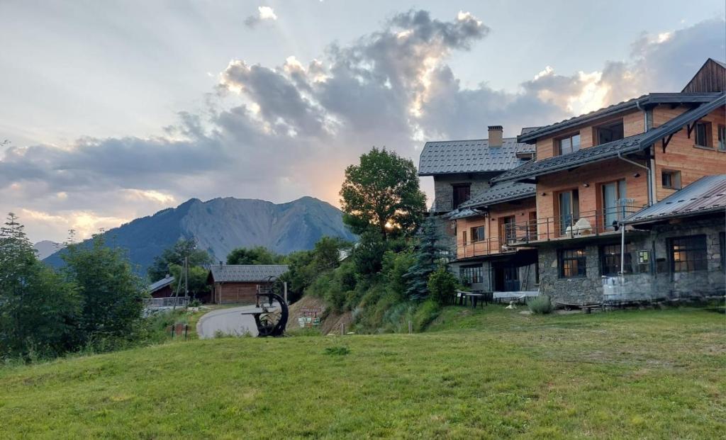 a house on a hill with mountains in the background at La scierie de la grande ourse in Albiez-Montrond