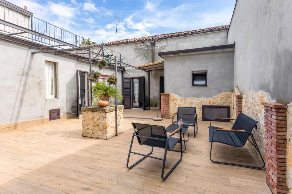 a patio with chairs and a table and a fireplace at La Papuzzella in Puntalazzo