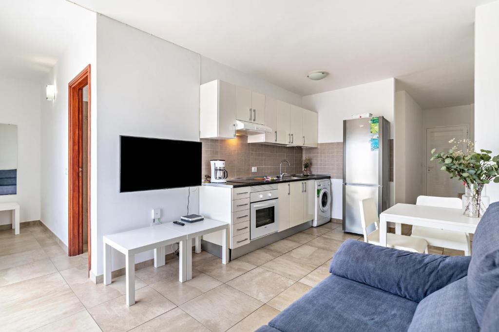 a kitchen and living room with a couch and a table at Barlovento Apartment in Playa Honda