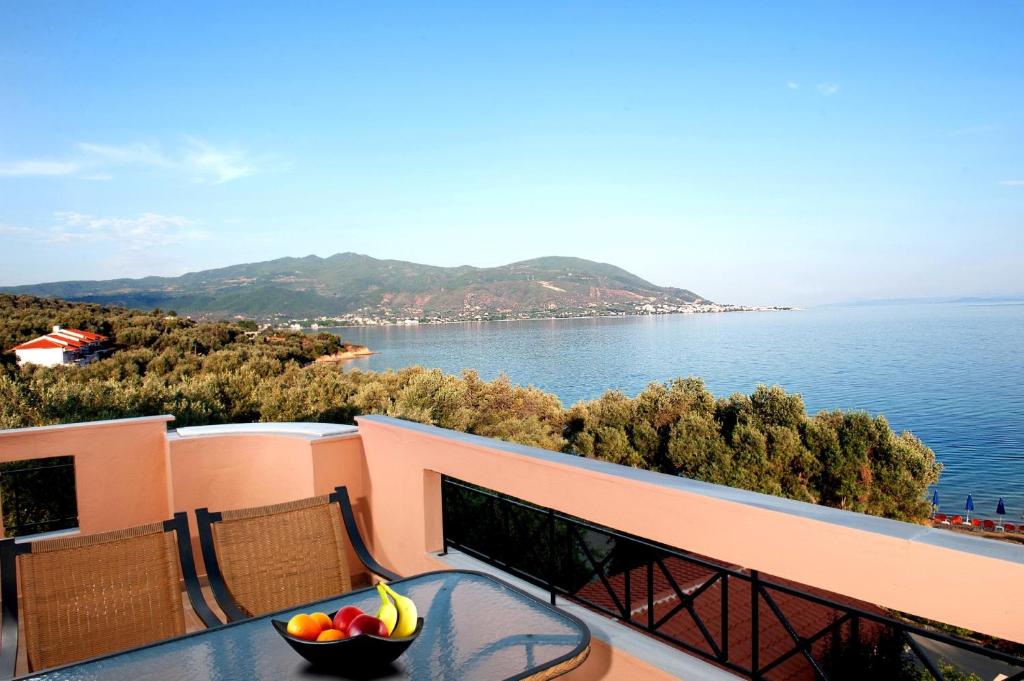 een fruitschaal op een tafel op een balkon met uitzicht op het water bij Effie's House in Áyios Nikólaos