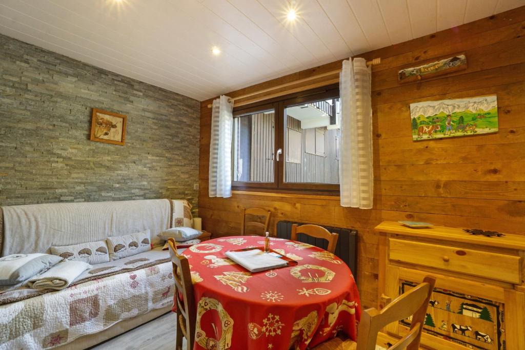 a room with a table and a bed and a window at Les Airelles 32 in Villarodin-Bourget