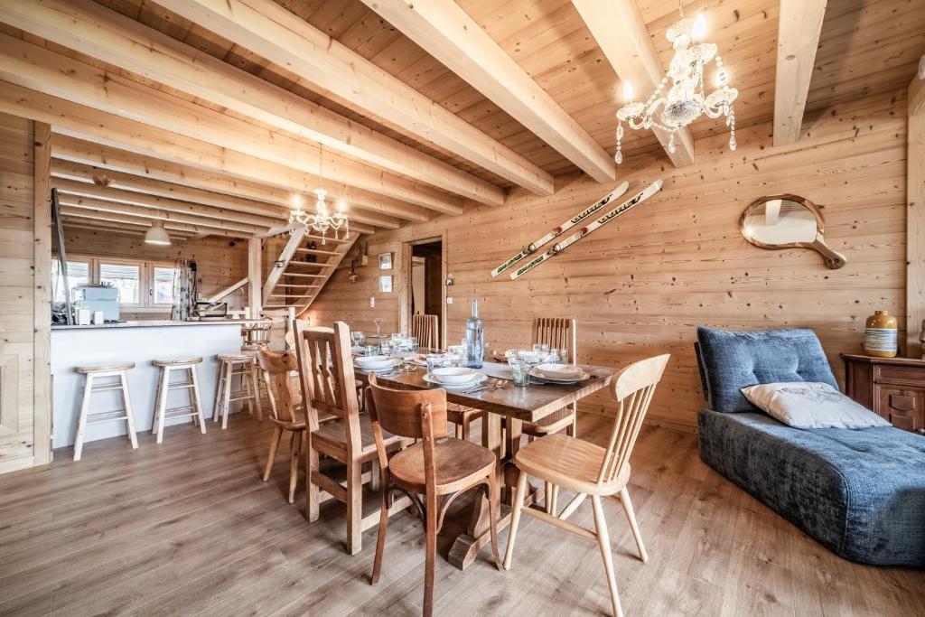 a dining room with a table and chairs and a couch at Le Chat Perché in Bernex