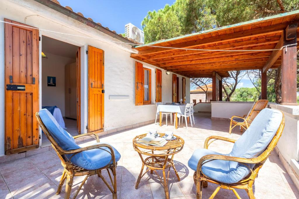 a patio with chairs and a table and a tableablish at Casa con terrazza nella Pineta in Codaruina