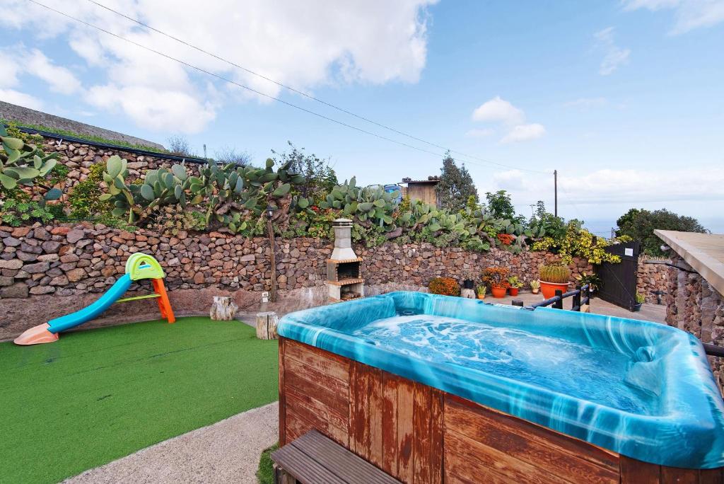 a backyard with a swimming pool and a play equipment at Hogar vacacional Maya in Santa Maria de Guia de Gran Canaria