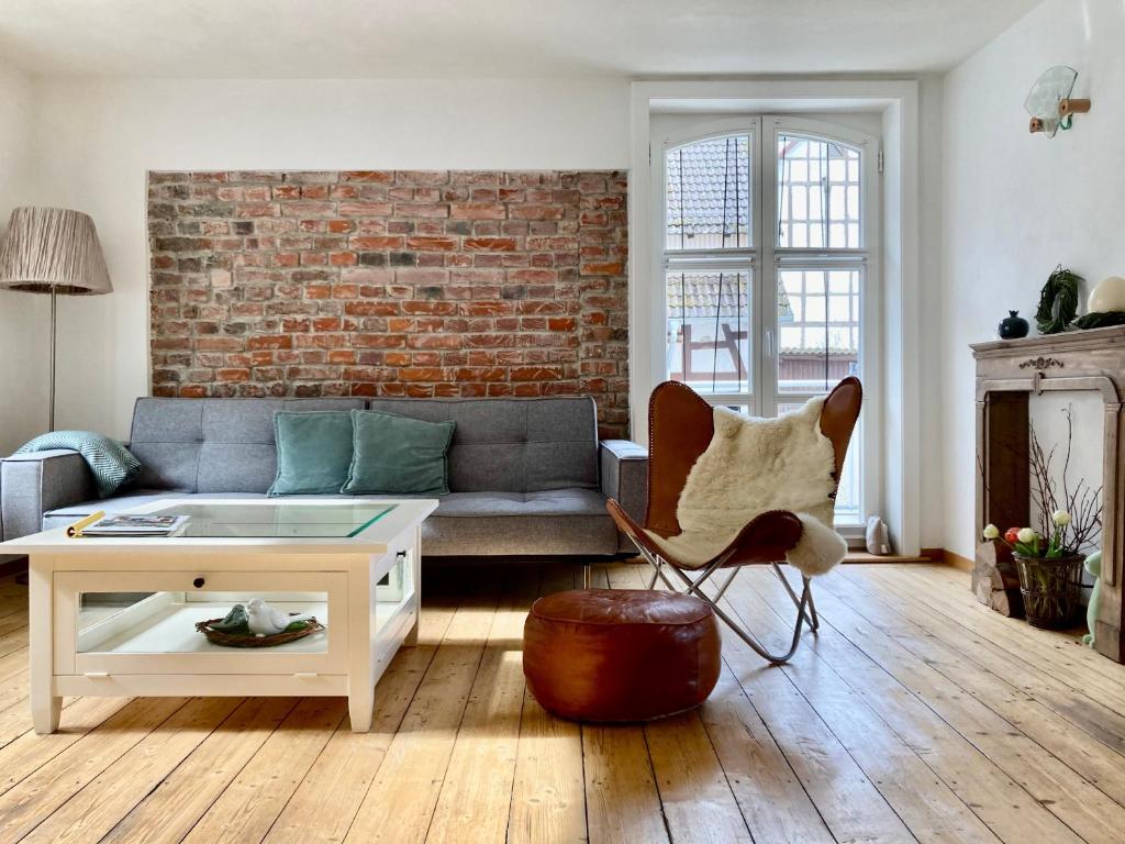 a living room with a couch and a brick wall at Ferienhaus bei Juste in Schotten