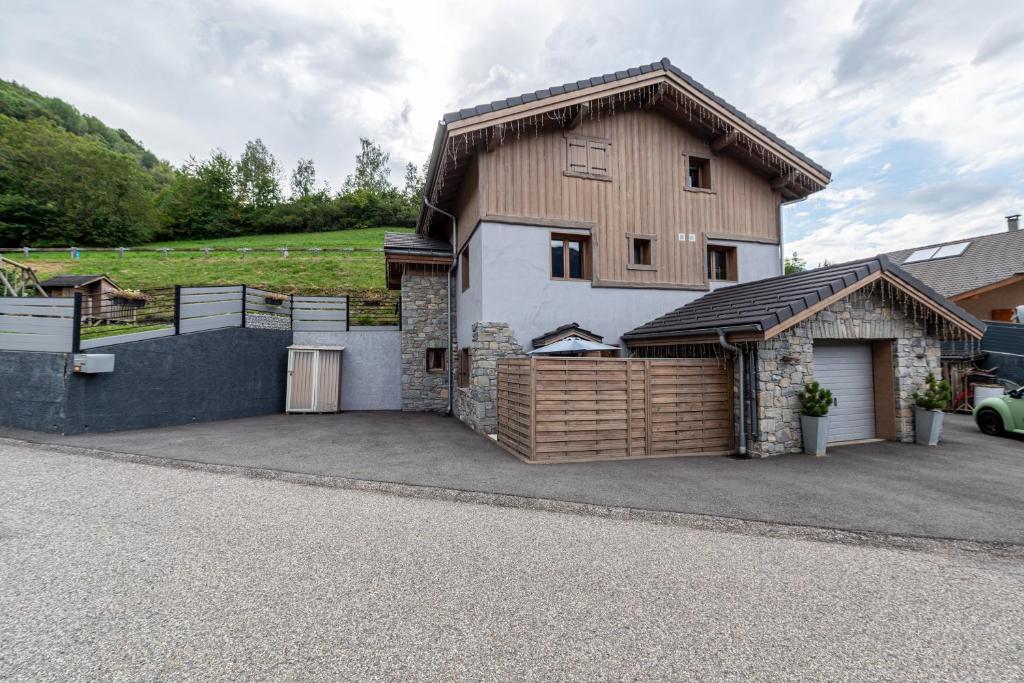 a detached house with a garage and a driveway at Joli Appartement Sur Le Bois in Aigueblanche