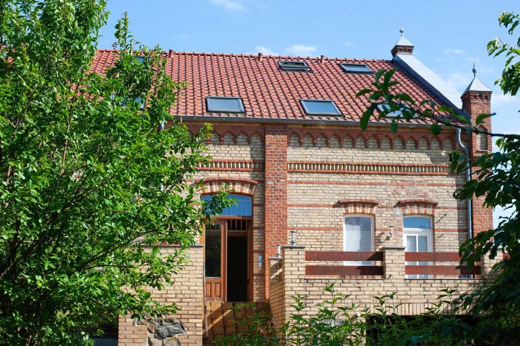 a brick house with a red roof at Gutshaus am Teich in Neukloster