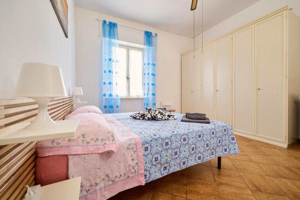 a bedroom with a pink bed and a window at Casabaffo in Piombino