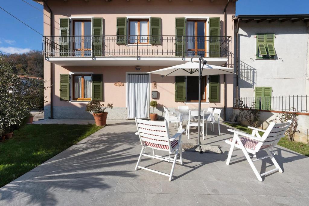 a patio with chairs and an umbrella in front of a house at Casa Vanda - 5 Terre in Arcola