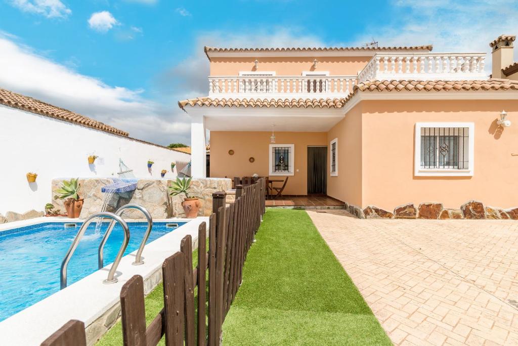 a villa with a swimming pool and a house at Casa Familiar La Lobita 2 in Conil de la Frontera