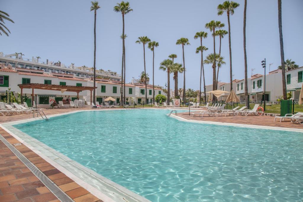 a swimming pool at a resort with palm trees at Bungalow El Caserío De Merengue in San Bartolomé