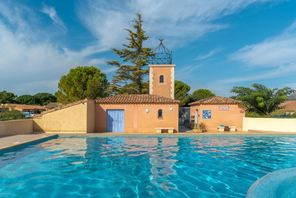 a villa with a pool in front of a building at Charming 2 bedroom House With Pool in Eyguières