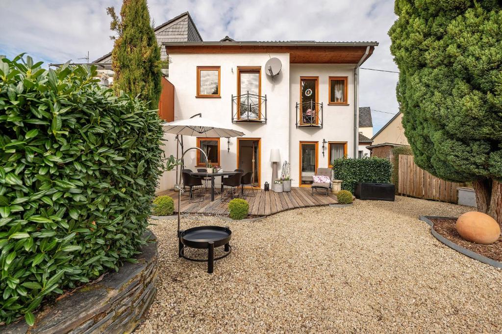 a house with a patio with a table and an umbrella at Casa Schneck in Longkamp
