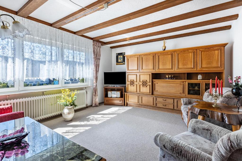 a living room with wooden cabinets and a table at Ferienwohnung Regina in Furtwangen