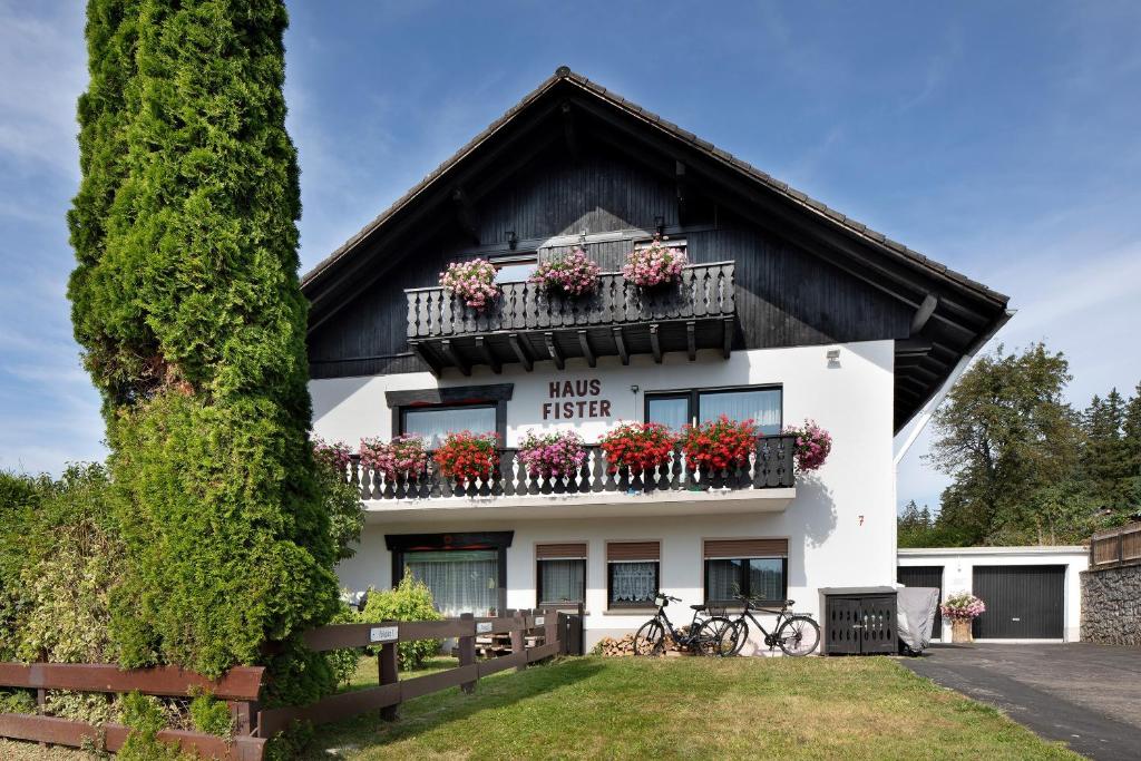 a house with flower boxes on the balcony at Apartmenthaus Fister in Schluchsee