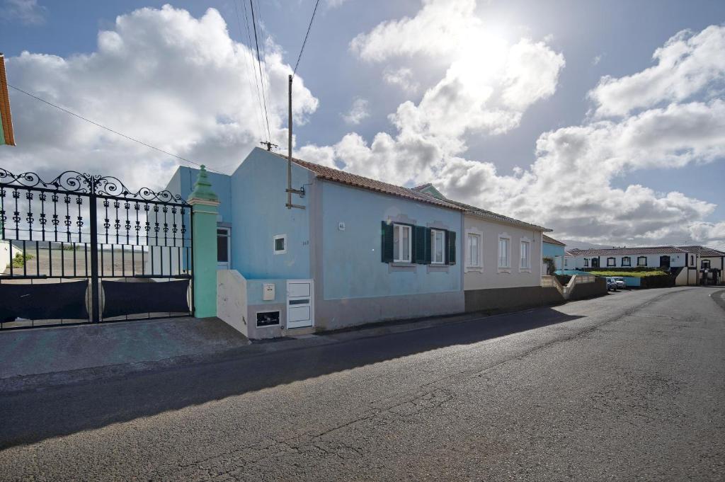 a building with a fence on the side of a street at Nuria House in Praia da Vitória