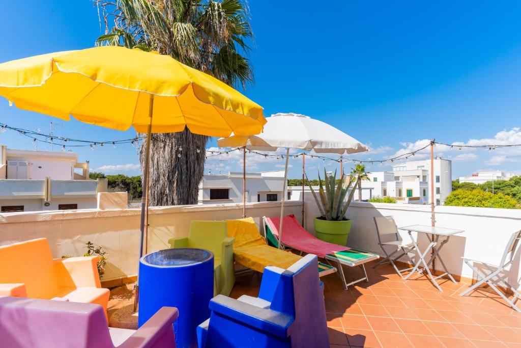 a patio with colorful chairs and an umbrella at Mini Appartamento verde in Gallipoli