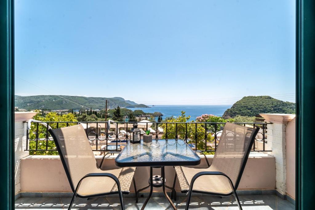a table and chairs on a balcony with a view of the ocean at Spyridoula Studio 3 in Paleokastritsa
