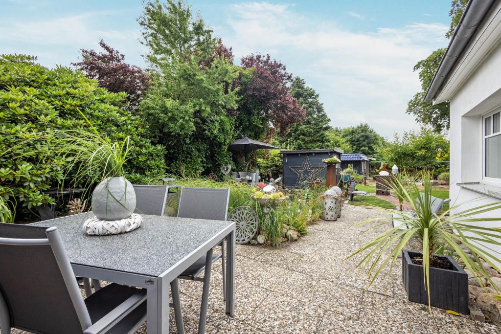 a patio with a table and chairs in a garden at Ferienwohnung Dahmlos in Kremperheide
