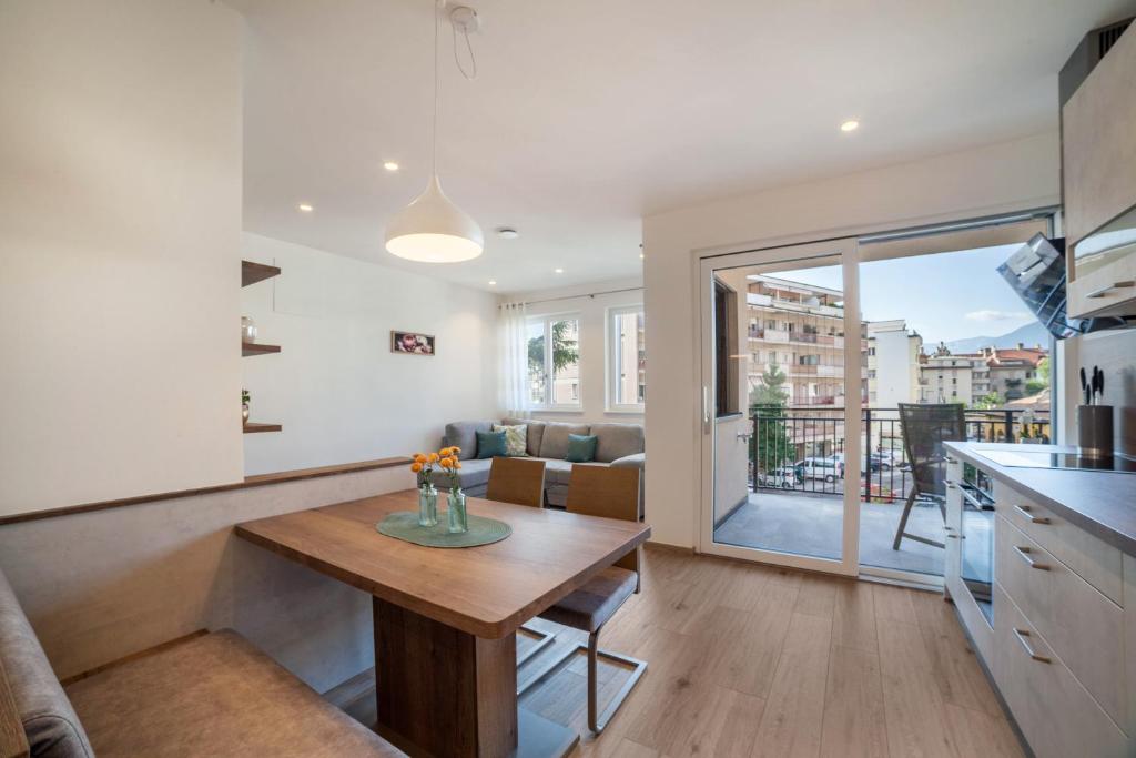 a kitchen and living room with a table in a kitchen at City Apartment Flora in Merano