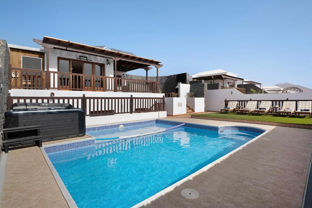 a swimming pool in front of a house at Villa Peaky in Yaiza
