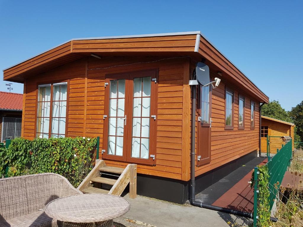 a small wooden cabin with a table and a patio at Ferienhaus Wolfshütte in Hillesheim