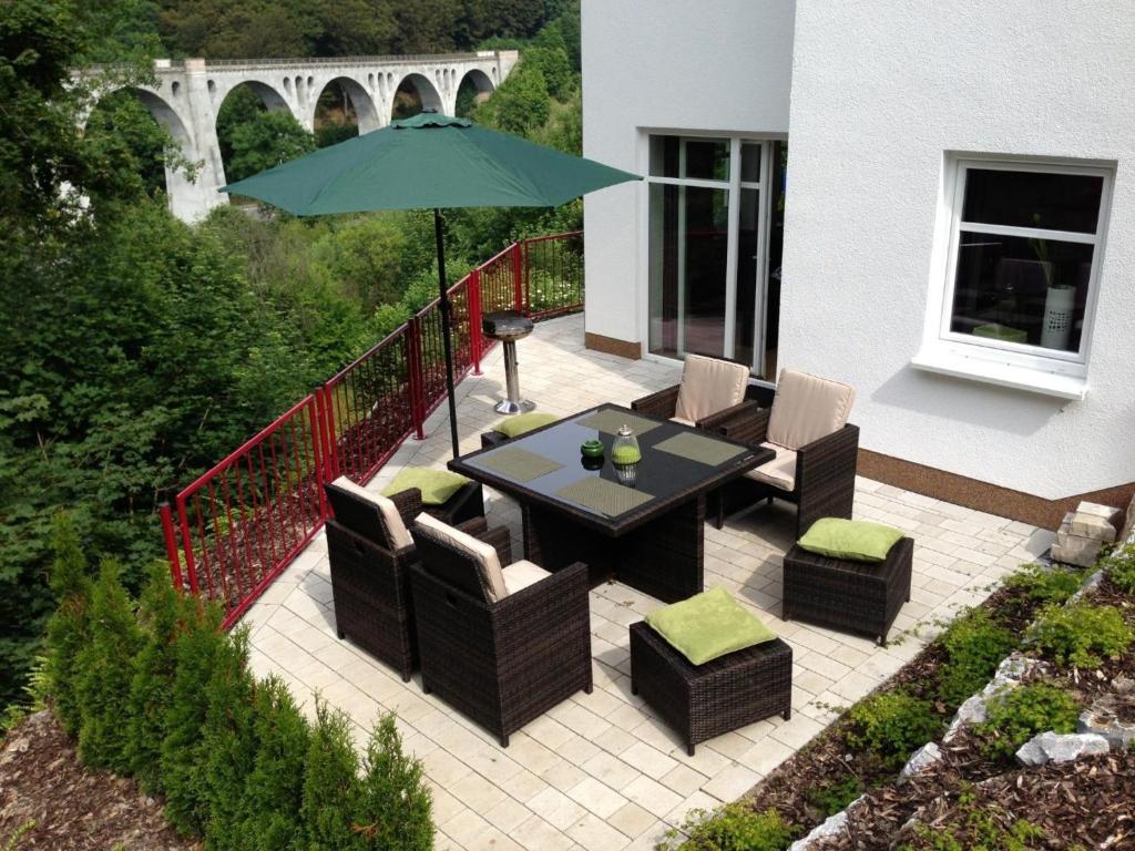 a patio with a table and chairs and an umbrella at Ferienwohnung Viadukt in Willingen