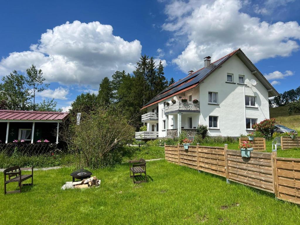 a white house with a fence in the yard at Ferienwohnung Karbachtal in Wangen im Allgäu