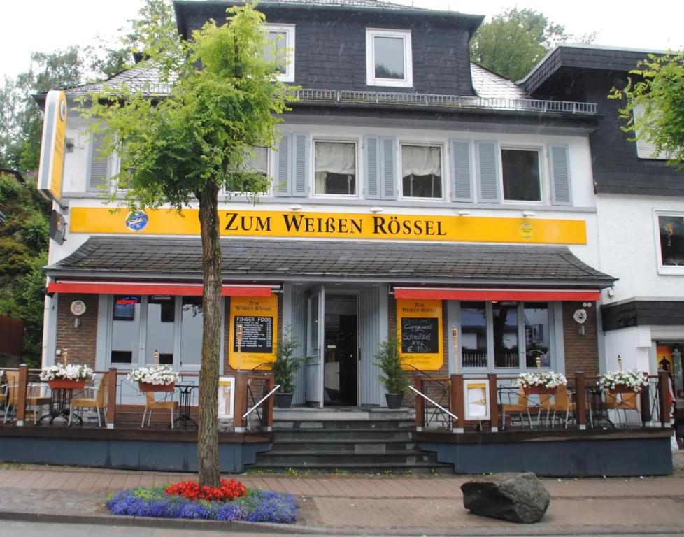 a yellow and white building with a table and chairs at Ferienwohnungen Roth in Willingen