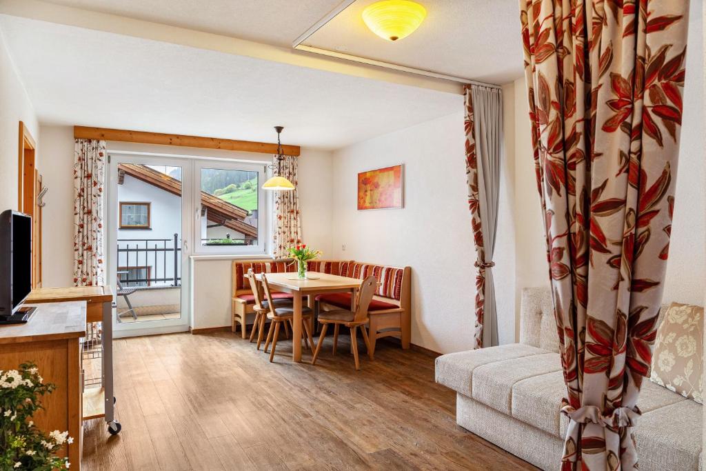 a living room with a table and a couch at Alpenflora 1 in Ischgl