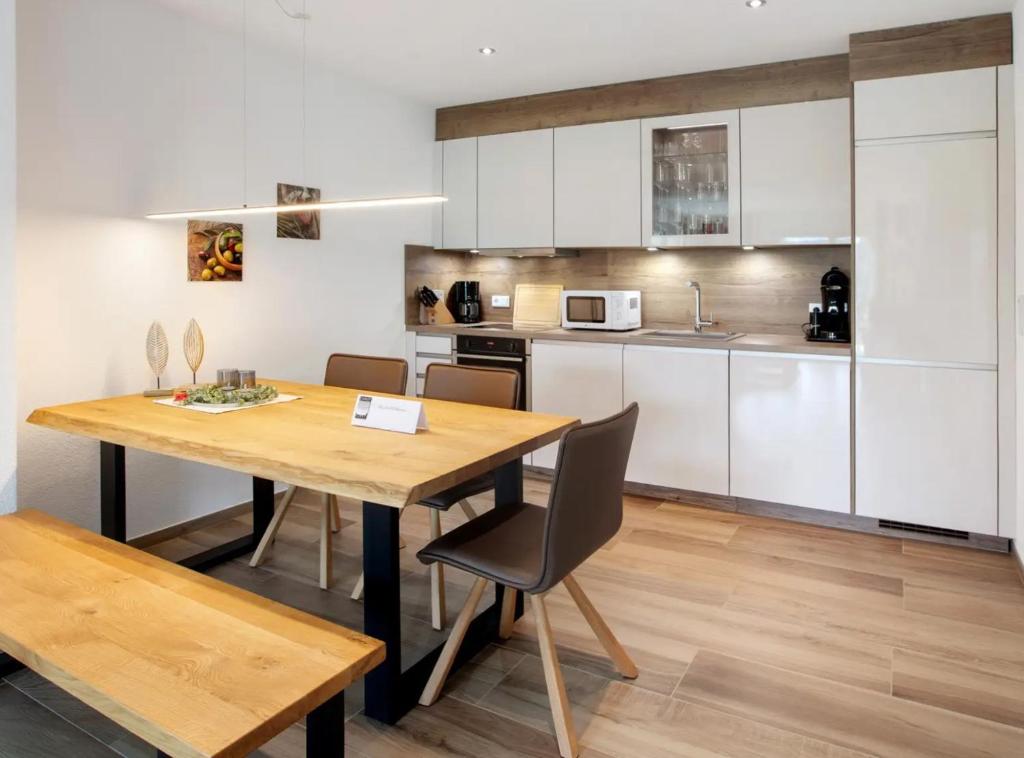 a kitchen and dining room with a wooden table and chairs at Chalet Foret - Ferienwohnung in Todtnauberg